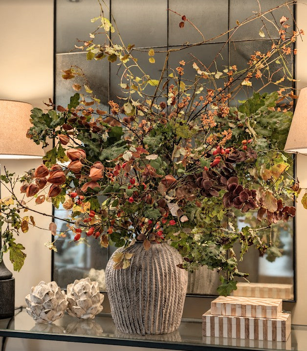 Large vase display of foliage and seasonal autumn stems